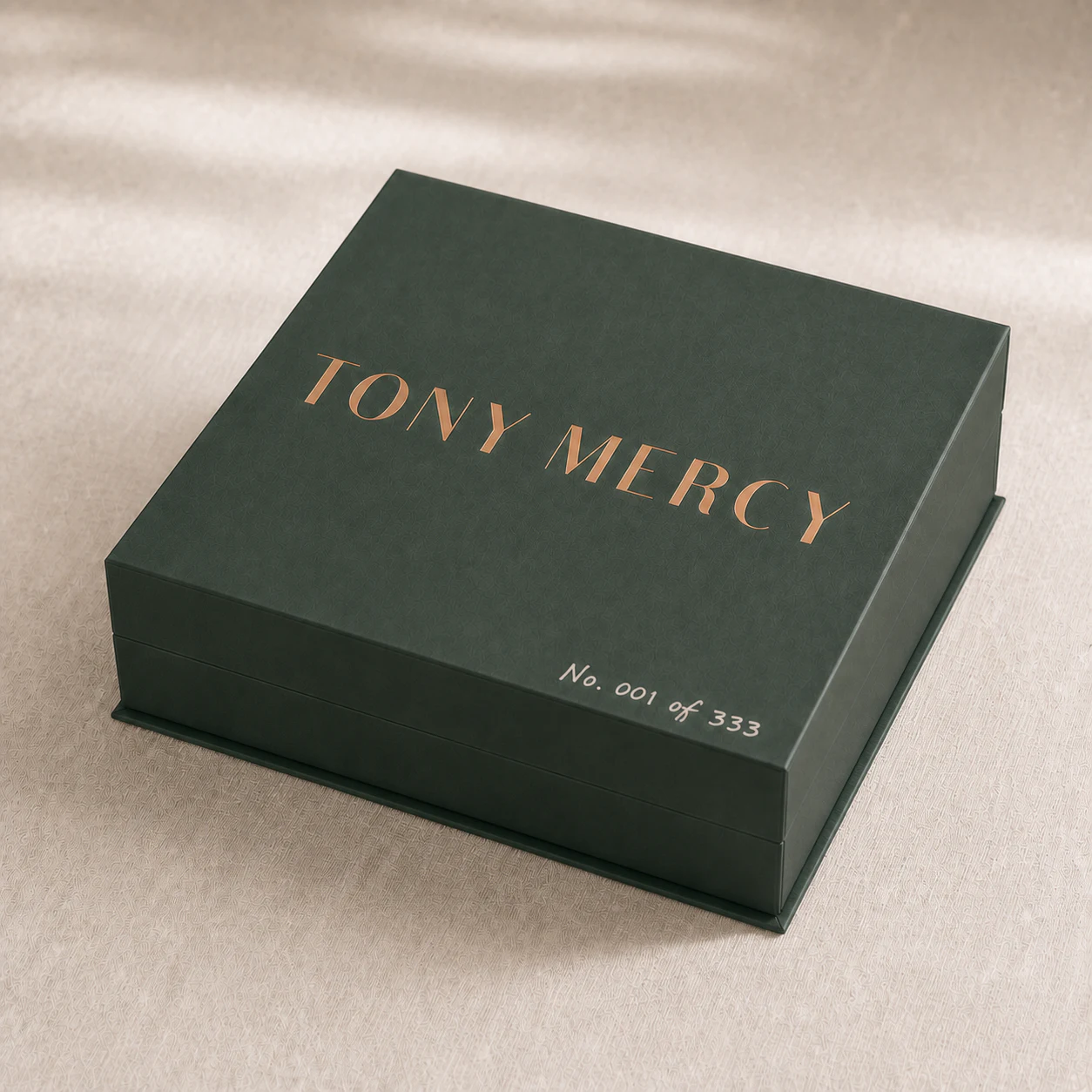 Concept render: the first numbered deep-pine magnetic box, marked No. 001 of 333 beneath a centered copper Tony Mercy wordmark